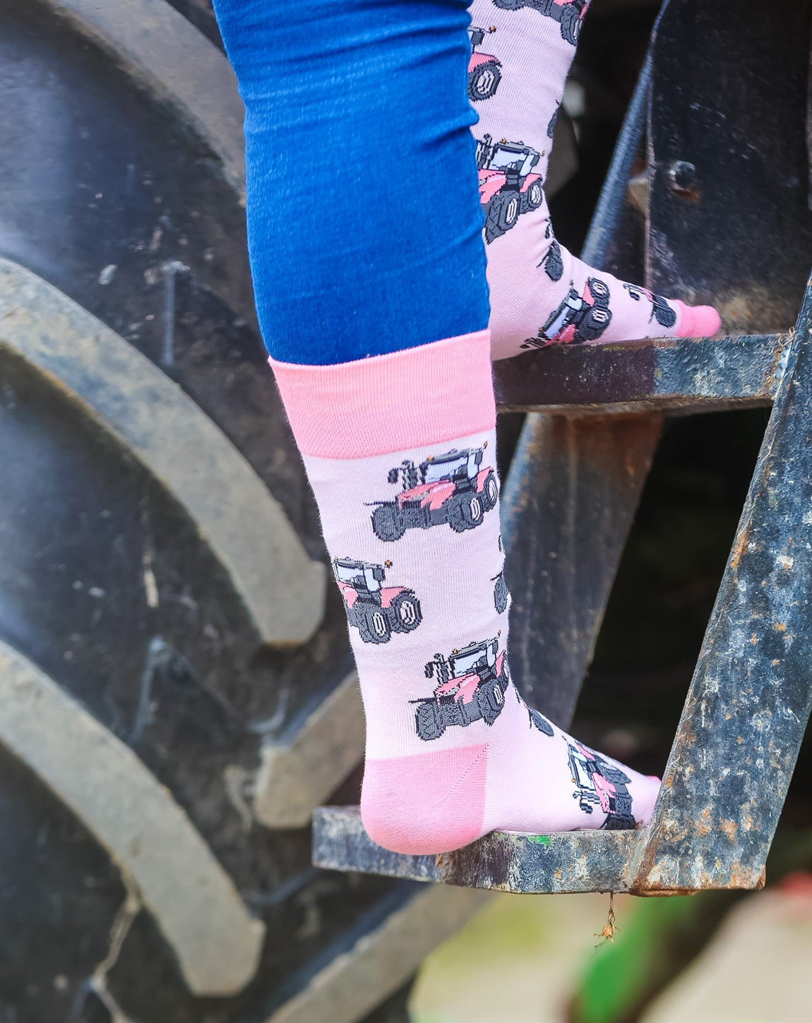 Vibrant pink tractor socks sporting bright pink tractors on a lighter pink background. Following on, the top, heel and toe is a matching tractor pink.