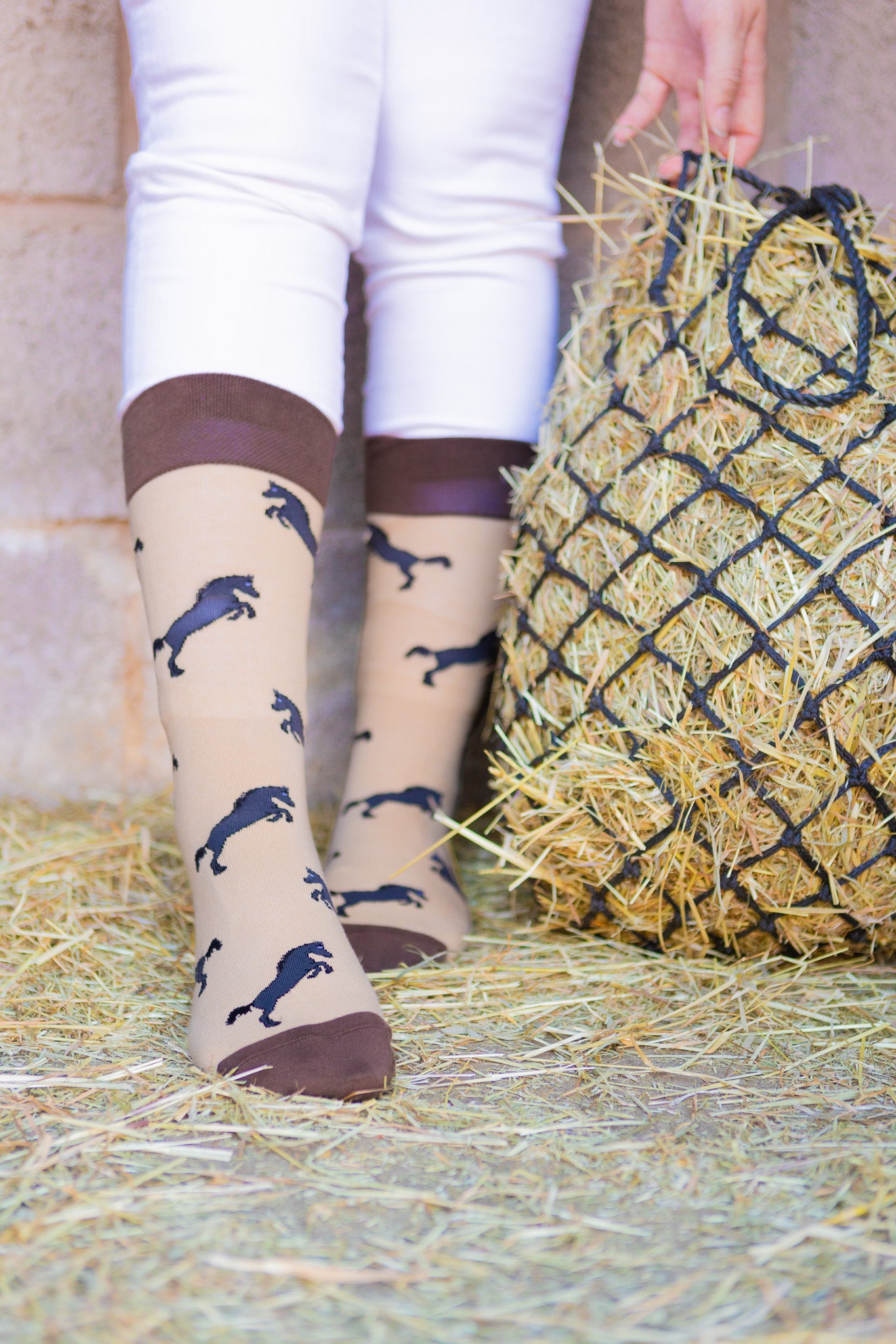 Elegant brown-themed horse socks featuring a stylish design of black rearing horses on a light brown background. The socks are accented with a more vibrant brown top, heel, and toe for added sophistication. Perfect for equestrian enthusiasts and horse lovers, these comfortable socks combine practicality with a chic country aesthetic, making them a great addition to any wardrobe and a lovely gift for those who appreciate the beauty of horses.