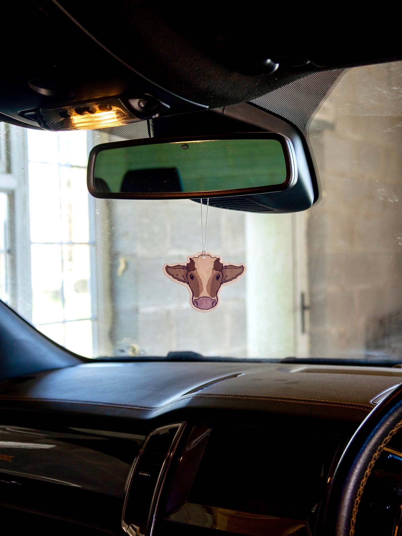 Brown cow air freshener with the scent of rainforest. Double sided print with hang string and safety instructions on the back.