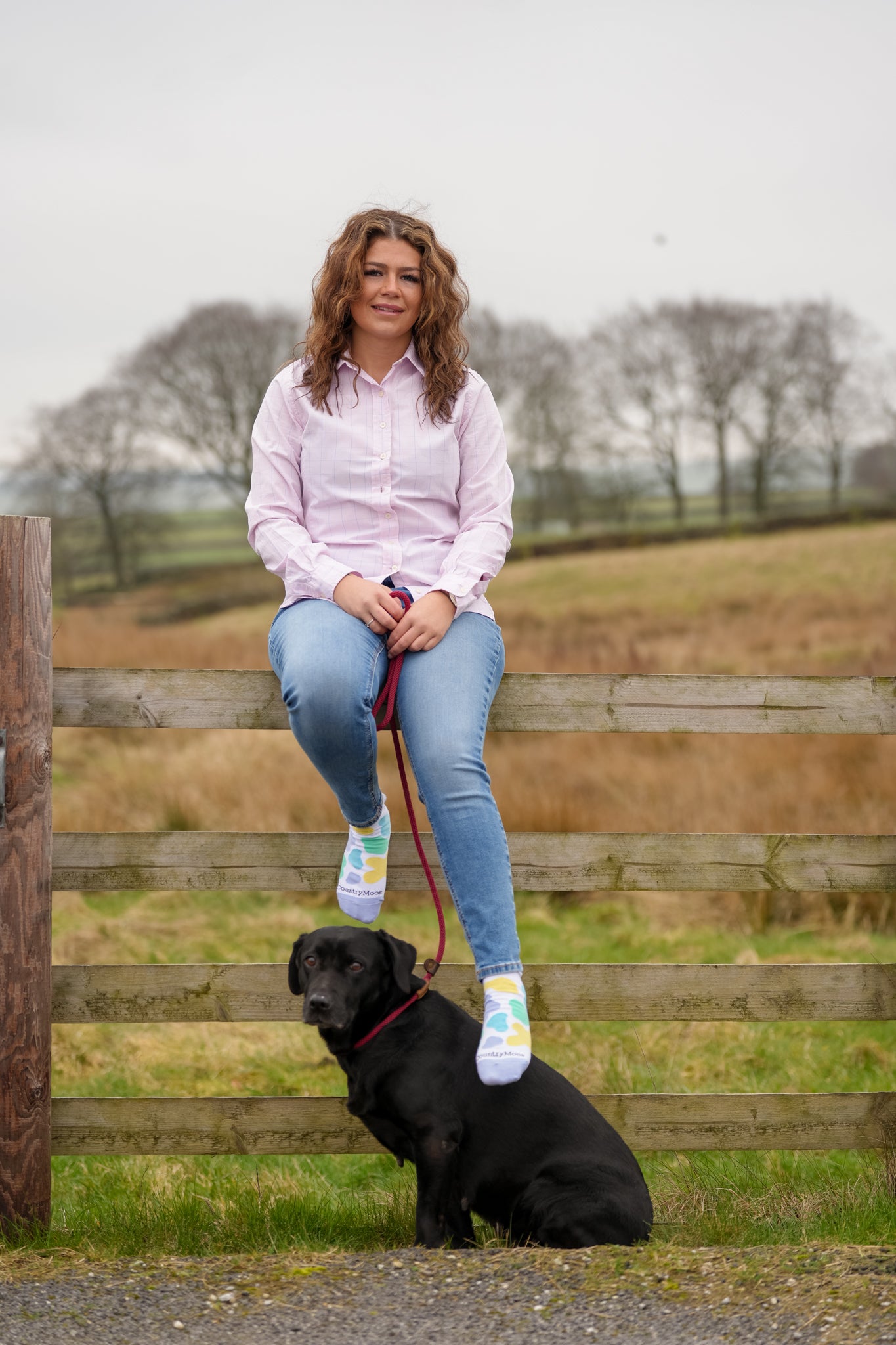 Country girl sat on fence wearing mix cow print ankle socks