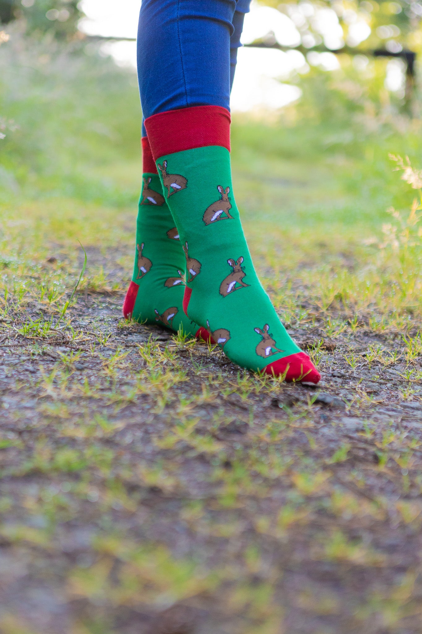 Charming country style hare socks set against a vibrant green background, adorned with playful hares and accented by bright red tops, heels, and toes. These eye-catching socks are perfect for nature lovers and those who appreciate whimsical countryside-themed fashion. A delightful addition to any sock collection, adding both comfort and a touch of personality.