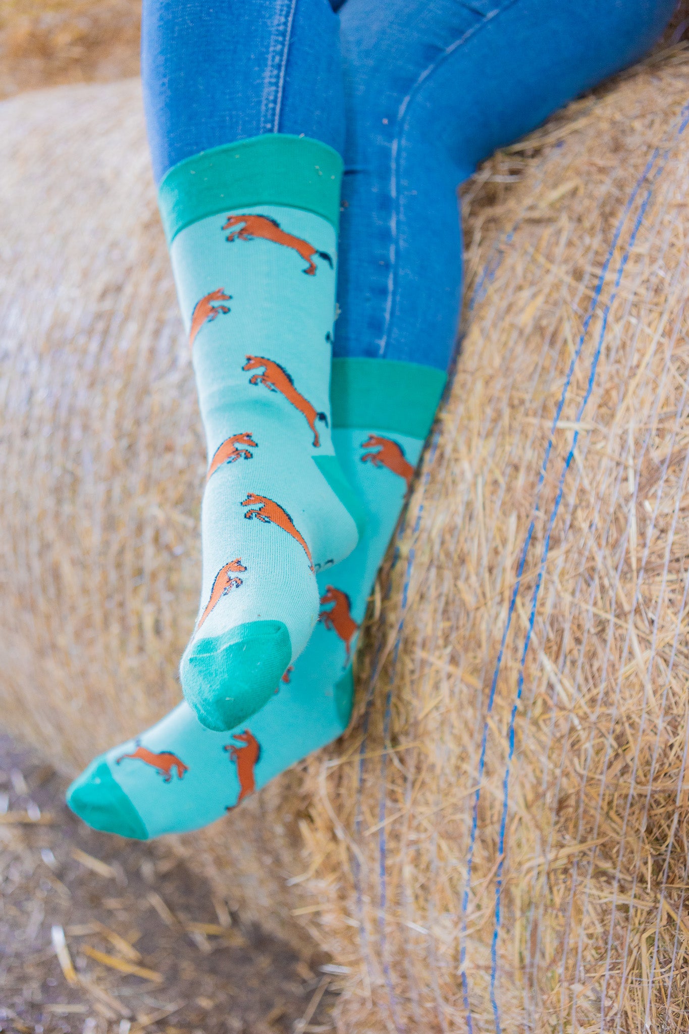 Green horse socks. Cosy crew socks with bay/brown rearing horses on a light green background and contrasting green top, heel and toe.