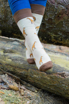 Unisex giraffe socks. Crew style footwear with brown and yellow giraffes on a cream background with a darker brown top, heel and toe.