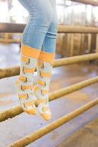 Jersey cow socks featuring adorable Jersey cow illustrations on a light brown background, with a slightly darker brown accent on the top, heel, and toe. These comfy country and stylish country style socks are perfect for cow and animal fans, adding a fun and unique touch to your outfit while celebrating the countryside and the outdoors.