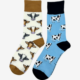 Mix cow socks featuring a cream background with a warm brown theme, alongside dairy cow socks adorned with classic black and white cows and coordinating matching tops, heels, and toes on a blue background. These stylish socks add the perfect touch to any country inspired outfit. Each design blends for both comfort and fashion are a great choice for those who cherish country life, countryside and great outdoor adventures.