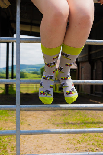 Country style forager socks showcasing a grey background embellished with vibrant green foragers, featuring matching green tops, heels, and toes. These cozy and stylish socks are the perfect addition to any sock drawer for countryside enthusiasts and outdoor lovers, adding a touch of rustic charm to your collection