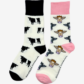 2 pairs of crew socks featuring a belted Galloway cow design on a light cream background, showcasing elegant black and white cows with an vibrantly elegant black top, heel, and toe. Also included are pink cow socks, set against light cream backdrop adorned with playful brown and black cows, complemented by a vibrant pink tops, heels, and toes. Perfect gifts for countryside enthusiasts, outdoor lovers and farming people, these cozy socks bring a touch of country style and comfort.