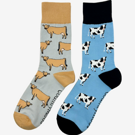 2 pairs of crew socks featuring jersey cow design on a light grey background, showcasing elegant brown cows with an vibrantly elegant brown top, heel, and toe. Also included are dairy cow socks, set against a light blue backdrop adorned with playful black and white cows, complemented by black tops, heels, and toes. Perfect gifts for countryside enthusiasts, outdoor lovers and farming people, these cozy socks bring a touch of country style and comfort.