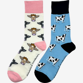 2 pairs of crew socks featuring a dairy cow design on a light bright blue background, showcasing elegant black and white cows with an vibrantly bold black top, heel, and toe. Also included are pink cow socks, set against light cream backdrop adorned with playful brown and black cows, complemented by a vibrant pink tops, heels, and toes. Perfect gifts for countryside enthusiasts, outdoor lovers and farming people, these cozy socks bring a touch of country style and comfort.