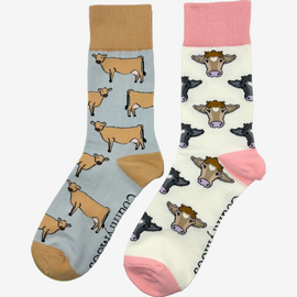 2 pairs of crew socks featuring jersey cow design on a light grey background, showcasing elegant brown cows with an vibrantly elegant brown top, heel, and toe. Also included are pink cow socks, set against a light cream backdrop adorned with playful brown and black cows, complemented by a vibrant pink tops, heels, and toes. Perfect gifts for countryside enthusiasts, outdoor lovers and farming people, these cozy socks bring a touch of country style and comfort.