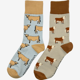 2 pairs of crew socks featuring jersey cow design on a light grey background, showcasing elegant brown cows with an vibrantly elegant brown top, heel, and toe. Also included are Hereford cattle cow socks, set against a light brown backdrop adorned with playful brown cows, complemented by a vibrant brown tops, heels, and toes. Perfect gifts for countryside enthusiasts, outdoor lovers and farming people, these cozy socks bring a touch of country style and comfort.