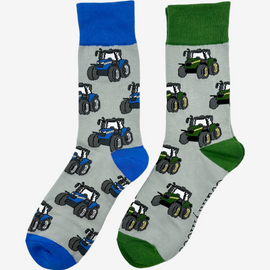 Two pairs of country style tractor socks, featuring green tractor socks on a grey background with green tops, heels, and toes, alongside blue tractor socks on a matching grey background with blue tractors and coordinating blue tops, heels, and toes. These fun and functional socks are perfect for farm enthusiasts, tractor lovers and outdoor countryside lovers who appreciate a stylish approach to country style clothing.