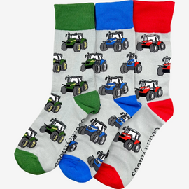 Three pairs of country style tractor socks, featuring red tractor socks on a grey background with red tops, heels, and toes, alongside green tractor socks on a matching grey background with green tractors and coordinating green tops, heels, and toes. Lastly blue tractor socks with grey background and blue top heel and toe. These fun and functional socks are perfect for farm enthusiasts, tractor lovers and outdoor countryside lovers who appreciate a stylish approach to country style clothing.