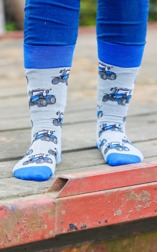 Blue country-style tractor socks featuring a modern tractor design on a grey background, accented with a matching blue top, heel, and toe. These cozy and stylish socks are perfect for farmers and tractor enthusiasts who love the countryside, offering both comfort and a touch of country charm for everyday wear.