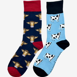 2 pairs of crew socks featuring a navy red cow design on a navy background, showcasing elegant brown cows with an elegant royal red top, heel, and toe. Also included are dairy cow socks, set against a blue backdrop adorned with playful black and white cows, complemented by black tops, heels, and toes. Perfect gifts for countryside enthusiasts, outdoor lovers and farming people, these cozy socks bring a touch of country style and comfort.