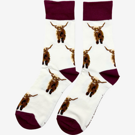 Elegant highland cow socks set against a cream background, adorned with charming brown top heel and toe accents and playful polka dots. Featuring delightful Highland cows, these cozy socks are perfect for adding a touch to your country style wardrobe while ensuring comfort for everyday wear.