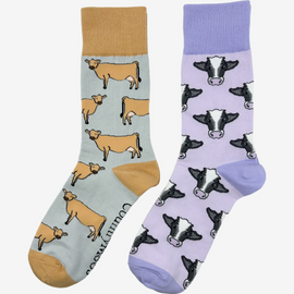 2 pairs of crew socks featuring a purple cow design on a light purple background, showcasing elegant black and brown cows with an elegant purple top, heel, and toe. Also included are Jersey cattle socks, set against a light brown backdrop adorned with playful brown jersey cows, complemented by matching brown tops, heels, and toes. Perfect gifts for countryside enthusiasts, outdoor lovers and farming people, these cozy socks bring a touch of country style and comfort