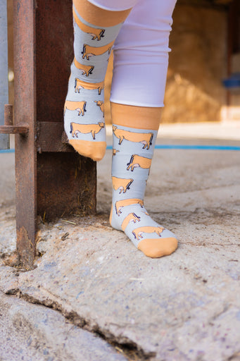 Jersey cow socks featuring adorable Jersey cow illustrations on a light brown background, with a slightly darker brown accent on the top, heel, and toe. These comfy country and stylish country style socks are perfect for cow and animal fans, adding a fun and unique touch to your outfit while celebrating the countryside and the outdoors.