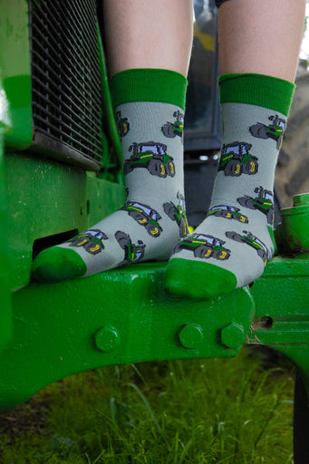 Green country-style tractor socks featuring a modern tractor design on a grey background, accented with a matching green top, heel, and toe. These cozy and stylish socks are perfect for farmers and tractor enthusiasts who love the countryside, offering both comfort and a touch of country charm for everyday wear.