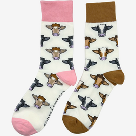 Mix cow socks featuring a cream background with a warm brown theme, alongside pink cow socks adorned with classic brown and black cows and coordinating pink tops, heels, and toes on a cream background. These stylish socks add the perfect touch to any country inspired outfit. Each design blends for both comfort and fashion are a great choice for those who cherish country life, countryside and great outdoor adventures.