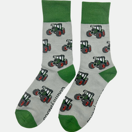 "These charming green tractor socks showcase a vibrant tractor design against a grey background, with matching green heel and toe accents. Ideal for completing a country outfit, they offer a touch of rustic style and comfort for your journeys around the farm. Celebrate your love for rural life with these stylish and cozy socks!"