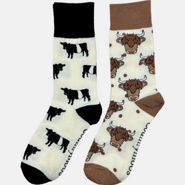 Adorable crew socks featuring a charming Belted Galloway design on a cream background, showcasing black and white cows with a sleek black top, heel, and toe. Also included are Highland cow socks, set against a cream backdrop adorned with playful brown highland cows and brown polka dots, complemented by matching brown tops, heels, and toes. Perfect gifts for countryside enthusiasts and farming lovers, these cozy socks bring a touch of country style and comfort to any wardrobe.