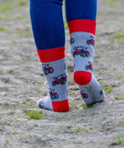 Unisex red tractor socks. These crew socks have vibrant red tractors on a light grey background with matching red top, heel and toe. 