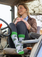 Unisex tractor socks. These vibrant crew socks have green tractors on a light grey background and matching green top, heel and toe. 
