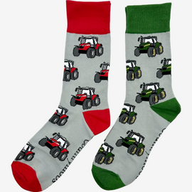 Two pairs of country style tractor socks, featuring red tractor socks on a grey background with red tops, heels, and toes, alongside green tractor socks on a matching grey background with green tractors and coordinating green tops, heels, and toes. These fun and functional socks are perfect for farm enthusiasts, tractor lovers and outdoor countryside lovers who appreciate a stylish approach to country style clothing.