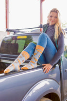 Jersey cow socks featuring adorable Jersey cow illustrations on a light brown background, with a slightly darker brown accent on the top, heel, and toe. These comfy country and stylish country style socks are perfect for cow and animal fans, adding a fun and unique touch to your outfit while celebrating the countryside and the outdoors.