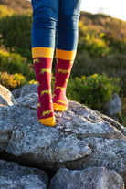 Bold lion socks featuring a striking bright red background adorned with playful lion graphics, complemented by bright yellow tops, heels, and toes. These eye-catching socks are perfect for animal lovers and those seeking to make a statement with their footwear. Ideal for adding a fun and vibrant touch to any outfit while ensuring comfort and style