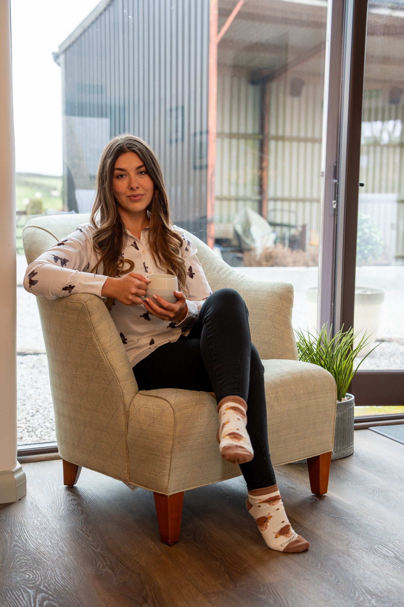 Country farm girl modelling highland cow ankle socks in a farmhouse