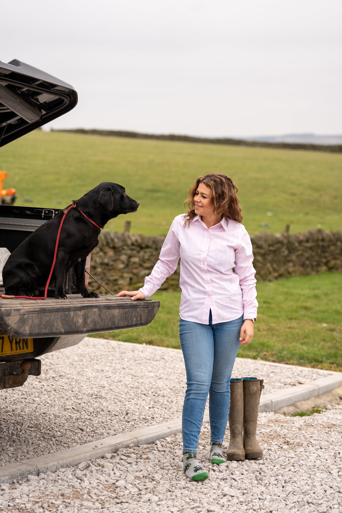 Country girl standing with her dog wearing Green tractor ankle socks 