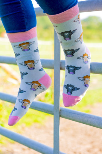 Pink cow socks featuring adorable cow designs on a soft cream background, complemented by a coordinating pink top, heel, and toe. These charming socks combine playful aesthetics with comfortable wear, making them a perfect accessory for cow enthusiasts and anyone looking to add a touch of elegance to their country outfit.