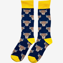 Highland cow long socks featuring a stunning navy background adorned with beautiful highland cow designs. The socks are accented with a vibrant gold/yellow top, heel, and toe, adding a pop of color and style. Ideal for outdoor adventures and country fashion enthusiasts, these cozy and eye-catching socks provide both warmth and flair. Perfect for pairing with casual outfits or adding a whimsical touch to your country-inspired wardrobe.