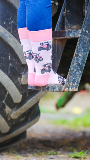 "These delightful pink tractor socks feature a lively tractor design set against a light pink background, complemented by matching pink heel and toe accents. Perfect for adding a pop of color to your country outfit, these socks combine comfort with a fun, rustic touch. Showcase your passion for farm life and cheerful style with these adorable and cozy socks!"