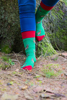 Charming country style hare socks set against a vibrant green background, adorned with playful hares and accented by bright red tops, heels, and toes. These eye-catching socks are perfect for nature lovers and those who appreciate whimsical countryside-themed fashion. A delightful addition to any sock collection, adding both comfort and a touch of personality.