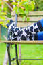 Black and white cow print socks showcasing a fun and trendy design inspired by classic cow patterns. Perfect for animal lovers, these stylish socks combine comfort and flair, making them ideal for everyday wear or adding a unique touch to your country outfit. Elevate your sock game with these chic cow print socks.