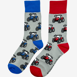 Two pairs of country style tractor socks, featuring red tractor socks on a grey background with red tops, heels, and toes, alongside blue tractor socks on a matching grey background with blue tractors and coordinating blue tops, heels, and toes. These fun and functional socks are perfect for farm enthusiasts, tractor lovers and outdoor countryside lovers who appreciate a stylish approach to country style clothing.