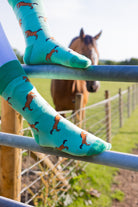 Elegant green-themed horse socks featuring stunning bay/brown rearing horses on a light green background with a contrasting green top, heel and toe.