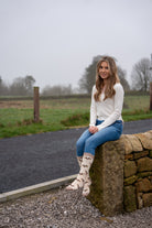 country girl sat wearing extra long friesian cow welly socks 